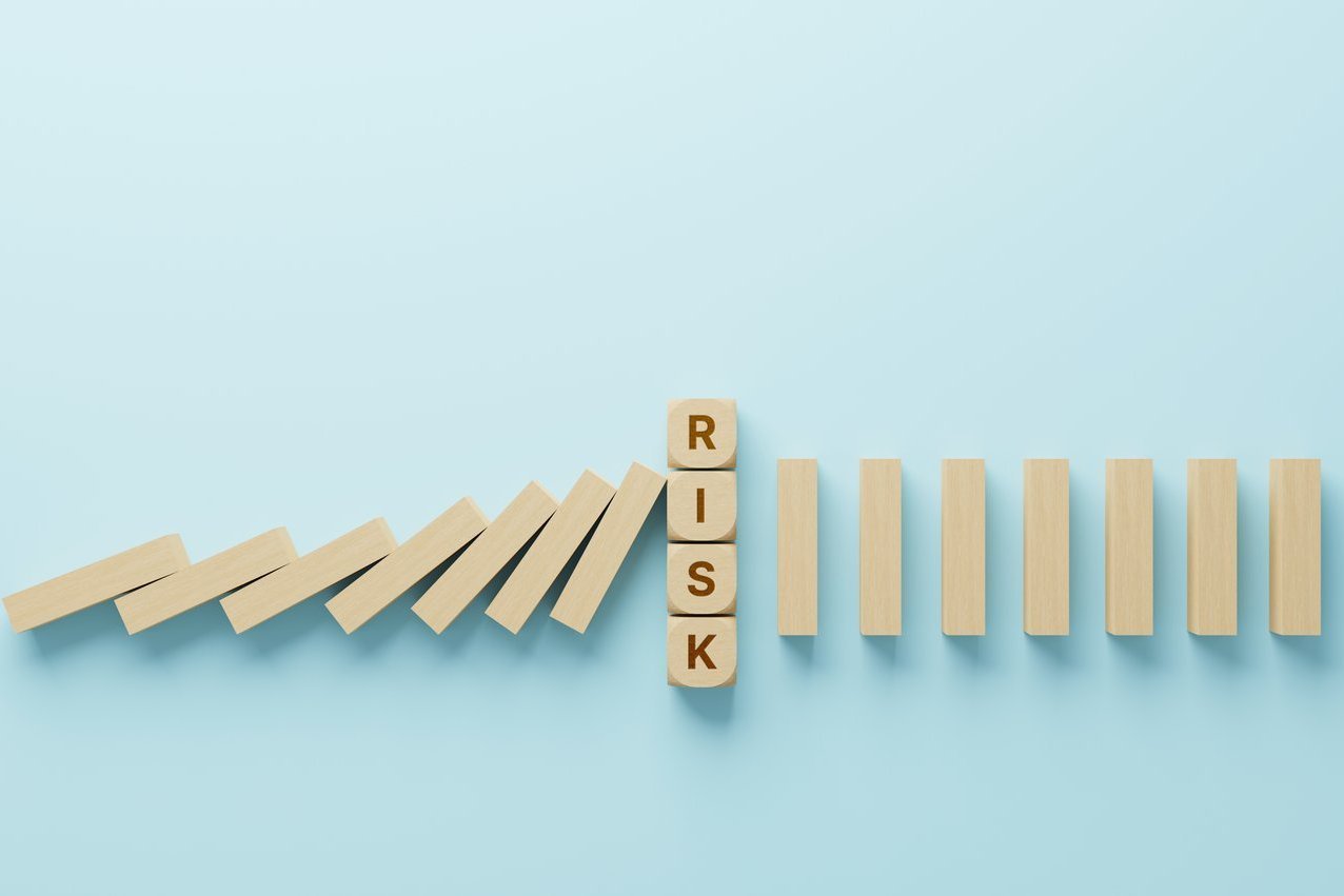 Dominoeffekt vor einem Risikoblock als Symbol für die frühzeitige Identifikation und Minimierung von Risiken in einem SAP S/4HANA Migrationsprojekt.