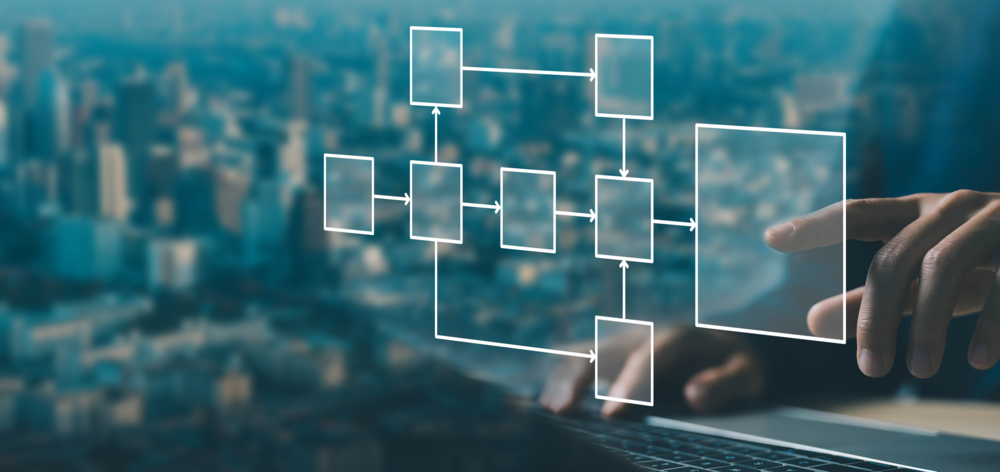 Geschäftsmann am Computer mit digital visualisierten Datenstrukturen, Prozessdiagrammen und vernetzten Abläufen.