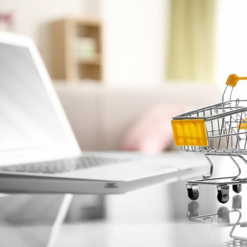Einkaufswagen vor einem Laptop als Symbol für den digitalen Source-to-Pay-Einkaufsprozess in SAP S/4HANA